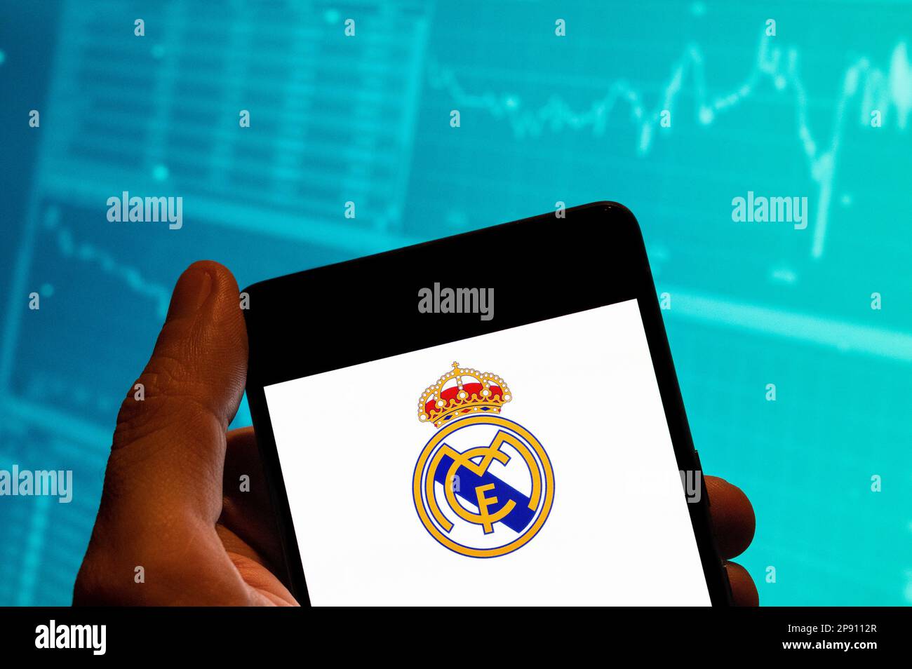 Chine. 15th févr. 2023. Dans cette illustration de photo, l'équipe de football professionnel espagnol Real Madrid Club de FÃºtbol communément connu sous le nom de logo Real Madrid est vu sur un smartphone avec un graphique de l'indice boursier économique en arrière-plan. (Credit image: © Budrul Chukrut/SOPA Images via ZUMA Press Wire) USAGE ÉDITORIAL SEULEMENT! Non destiné À un usage commercial ! Banque D'Images