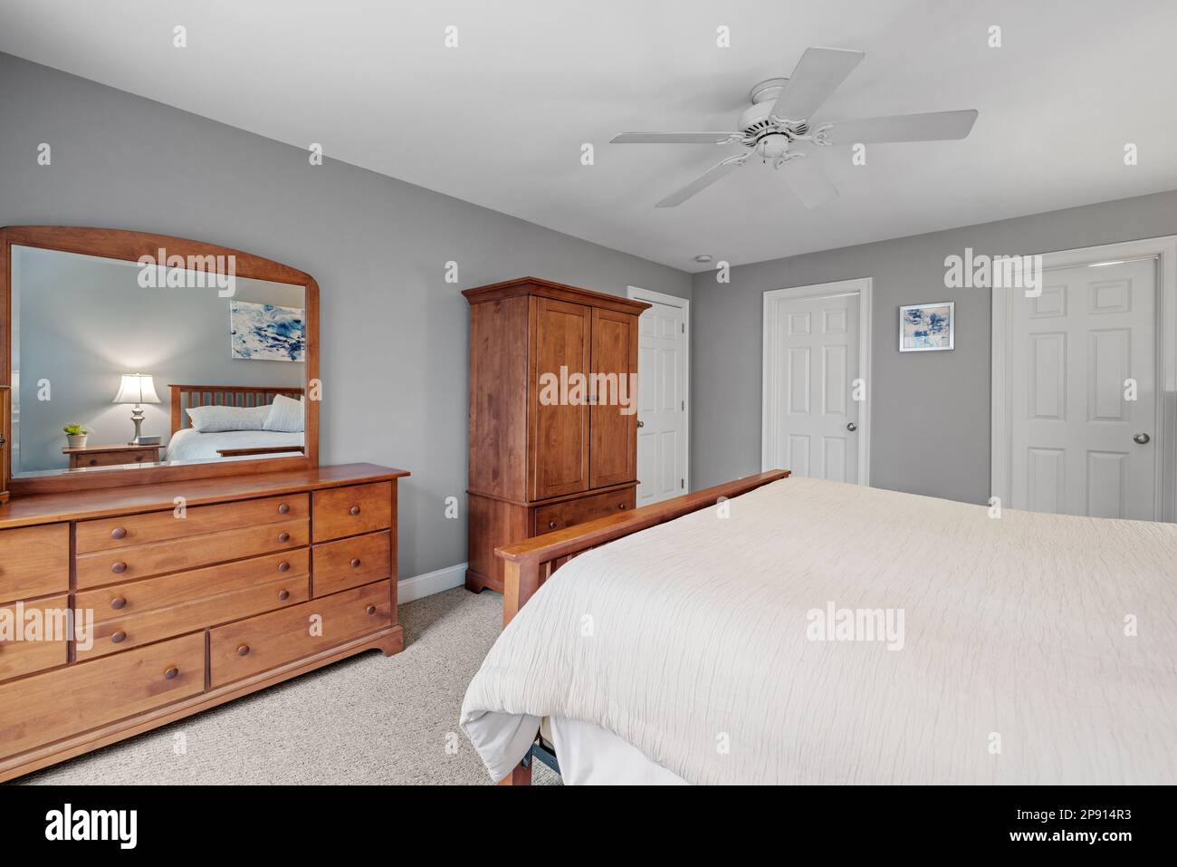 Un intérieur confortable, meublé avec un lit simple, une commode et un ventilateur de plafond Banque D'Images