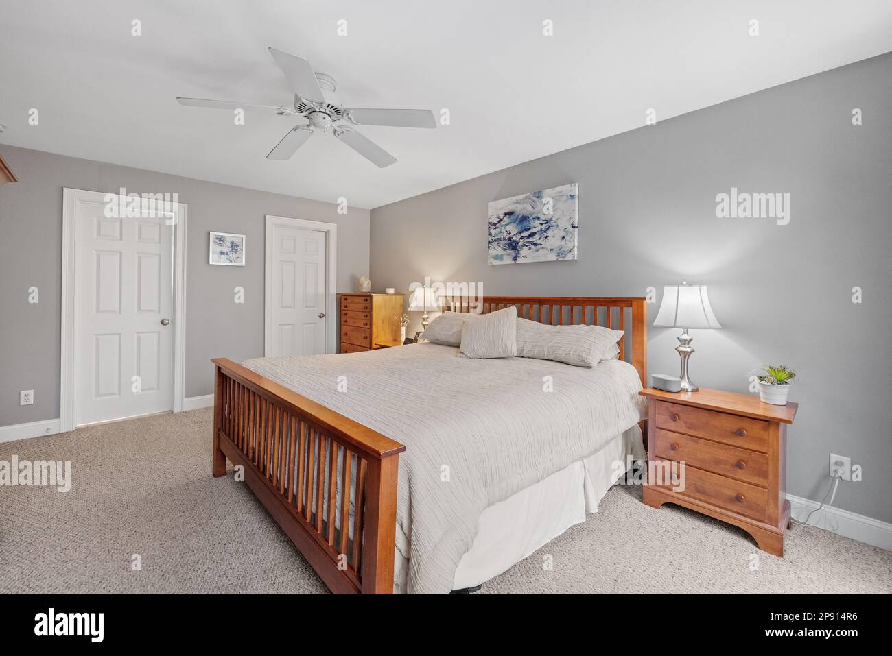 Un intérieur confortable, meublé avec un lit simple, une commode et un ventilateur de plafond Banque D'Images