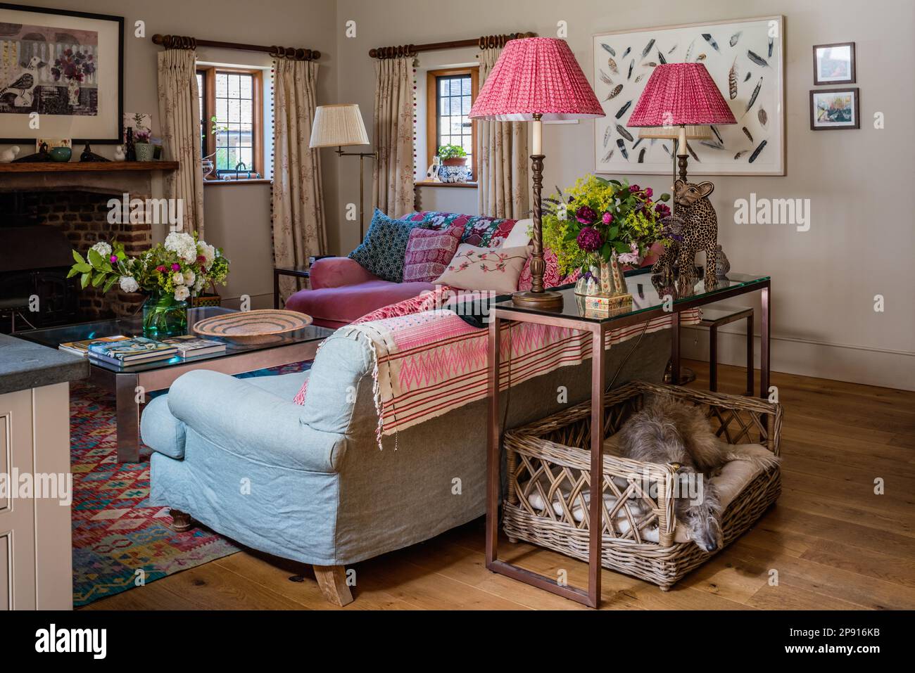 Paire de lampes roses sur console en verre avec panier pour chien dans le manoir élisabéthain du 16th siècle, Suffolk, Royaume-Uni Banque D'Images