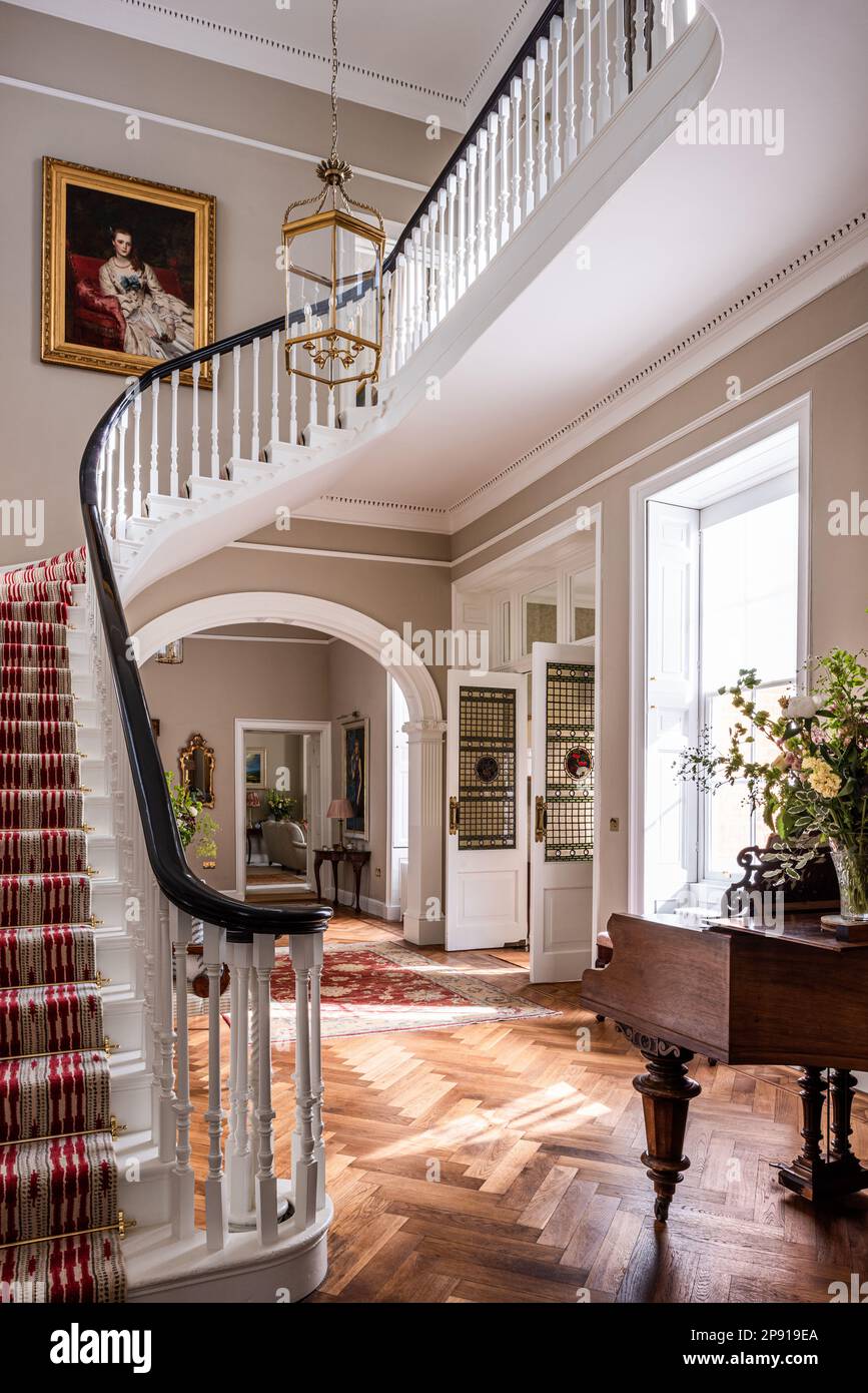 Escalier avec piano à queue dans l'entrée rénovée du 18th Century Grade II classé Suffolk Country House, Royaume-Uni Banque D'Images