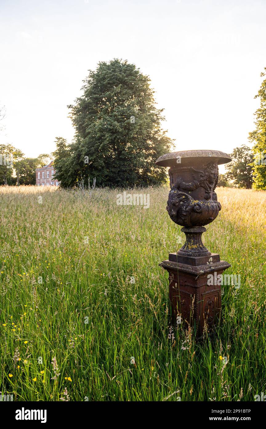 Ancienne urne dans les prairies sauvages de 18th Century Grade II classé Suffolk Country House, Royaume-Uni Banque D'Images