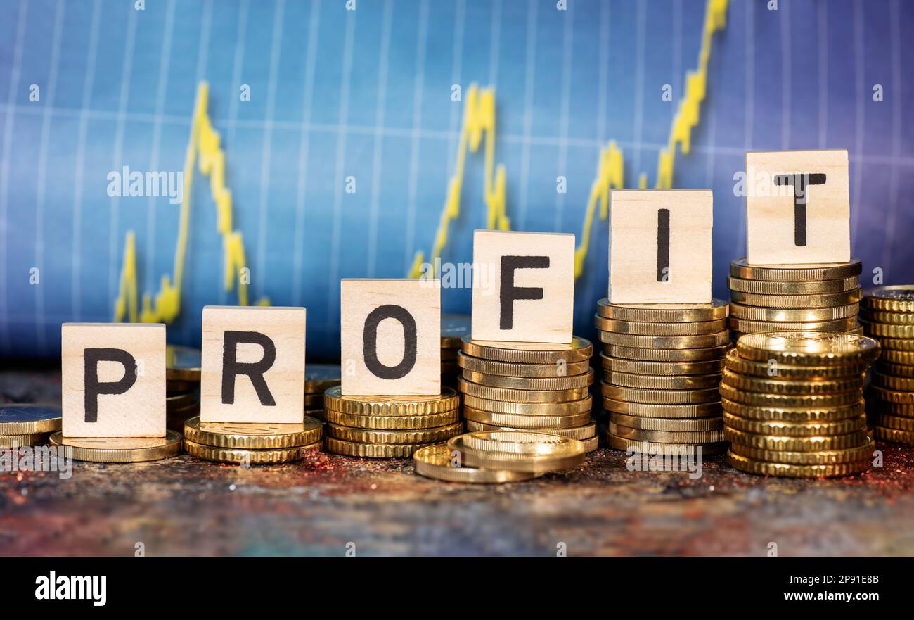 Plusieurs piles avec des pièces et le terme profit et un graphique avec la courbe ascendante. Banque D'Images