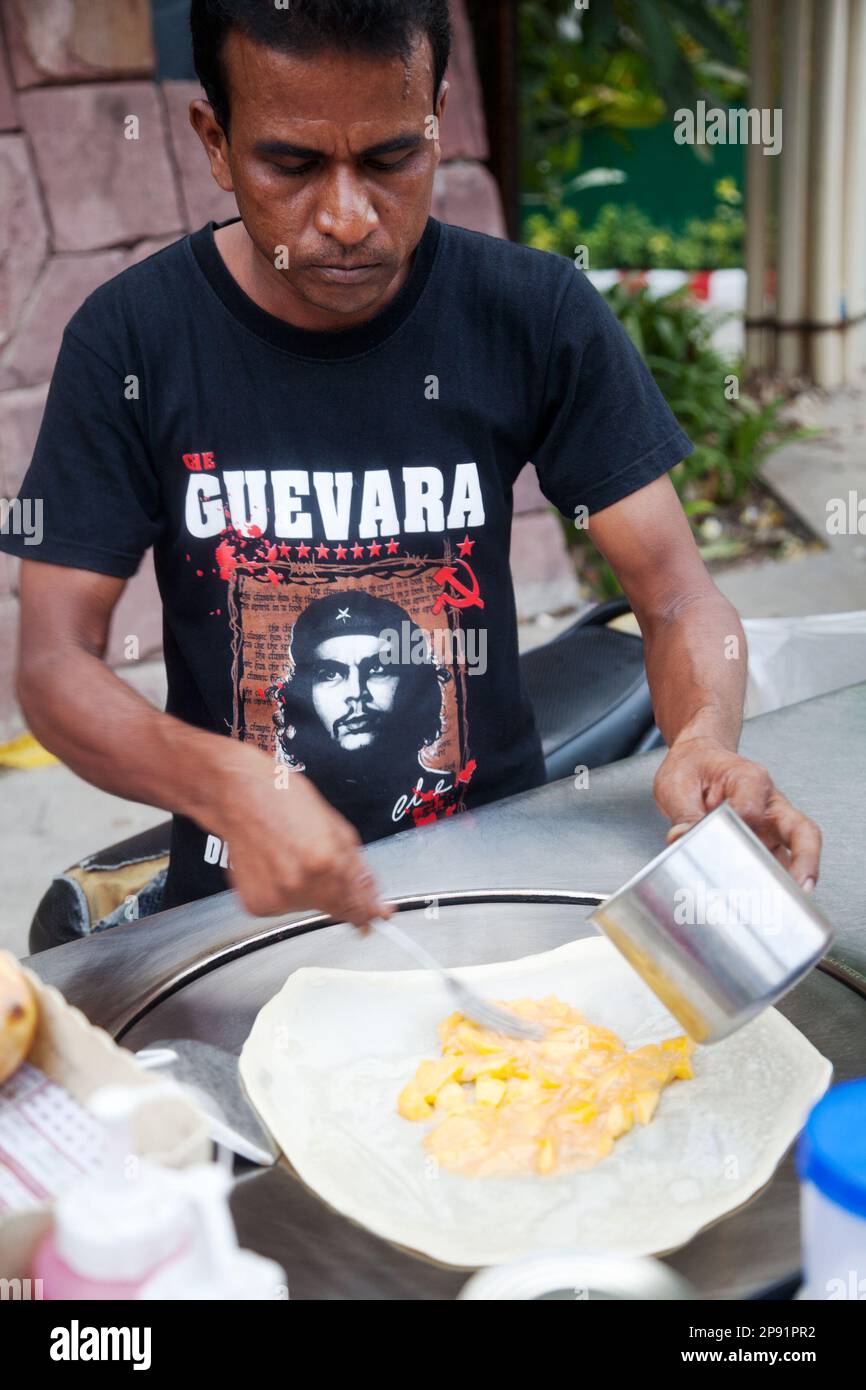 Pattaya, Thaïlande - 22 mars 2016: Un Indien cuisant une crêpe farcie à la mangue sur une charrette de la rue en Thaïlande, portant le T-shirt Che Guevara Banque D'Images