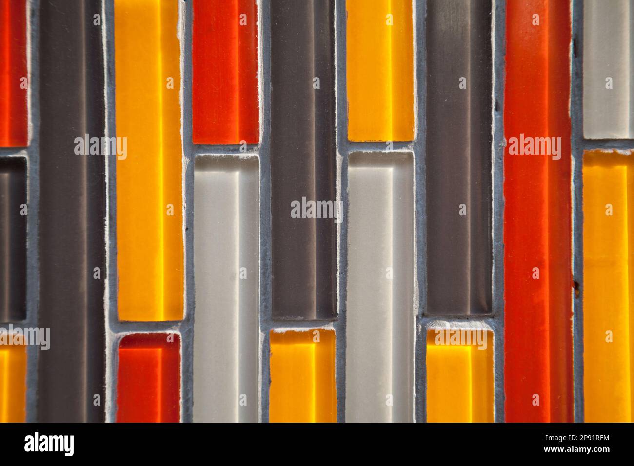 Verre coloré vertical rectangulaire mur carrelé gros plan: Jaune, rouge, blanc, noir motif. Mosaïques multicolores Banque D'Images