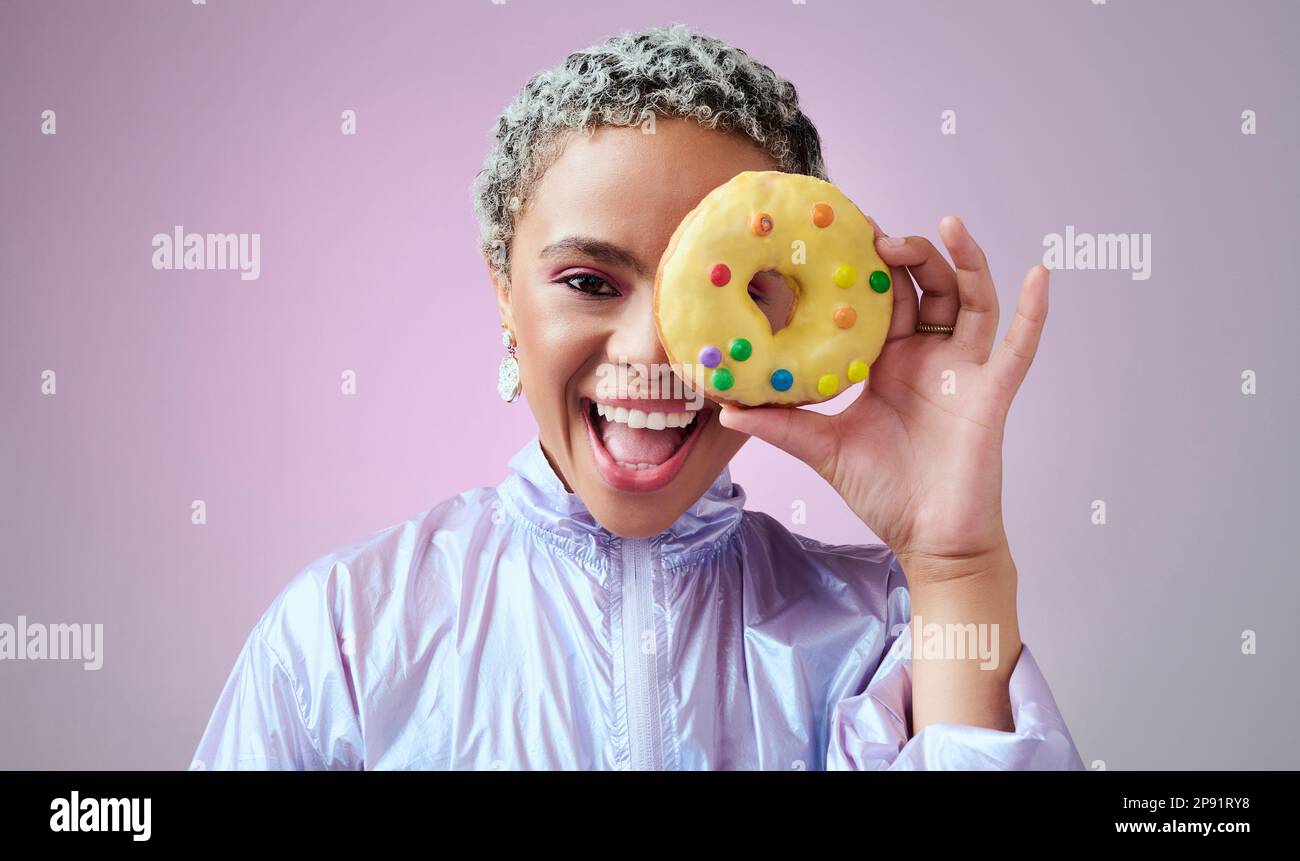 Femme noire, donut et mode excitée et heureuse de peeking à travers le dessert avec le style futuriste vaporwave et holographique et fond violet. Face Banque D'Images