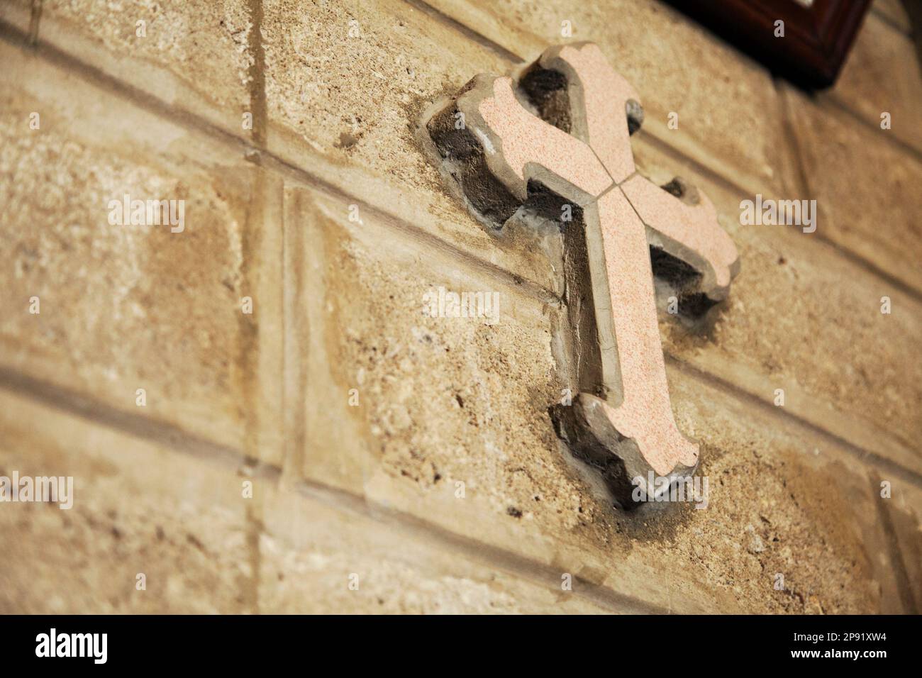Croix décorative sur un mur de brique de l'église catholique. Symbole du Christianisme historique avec l'exemplaire de l'espace. Détail de la décoration de la chapelle Banque D'Images