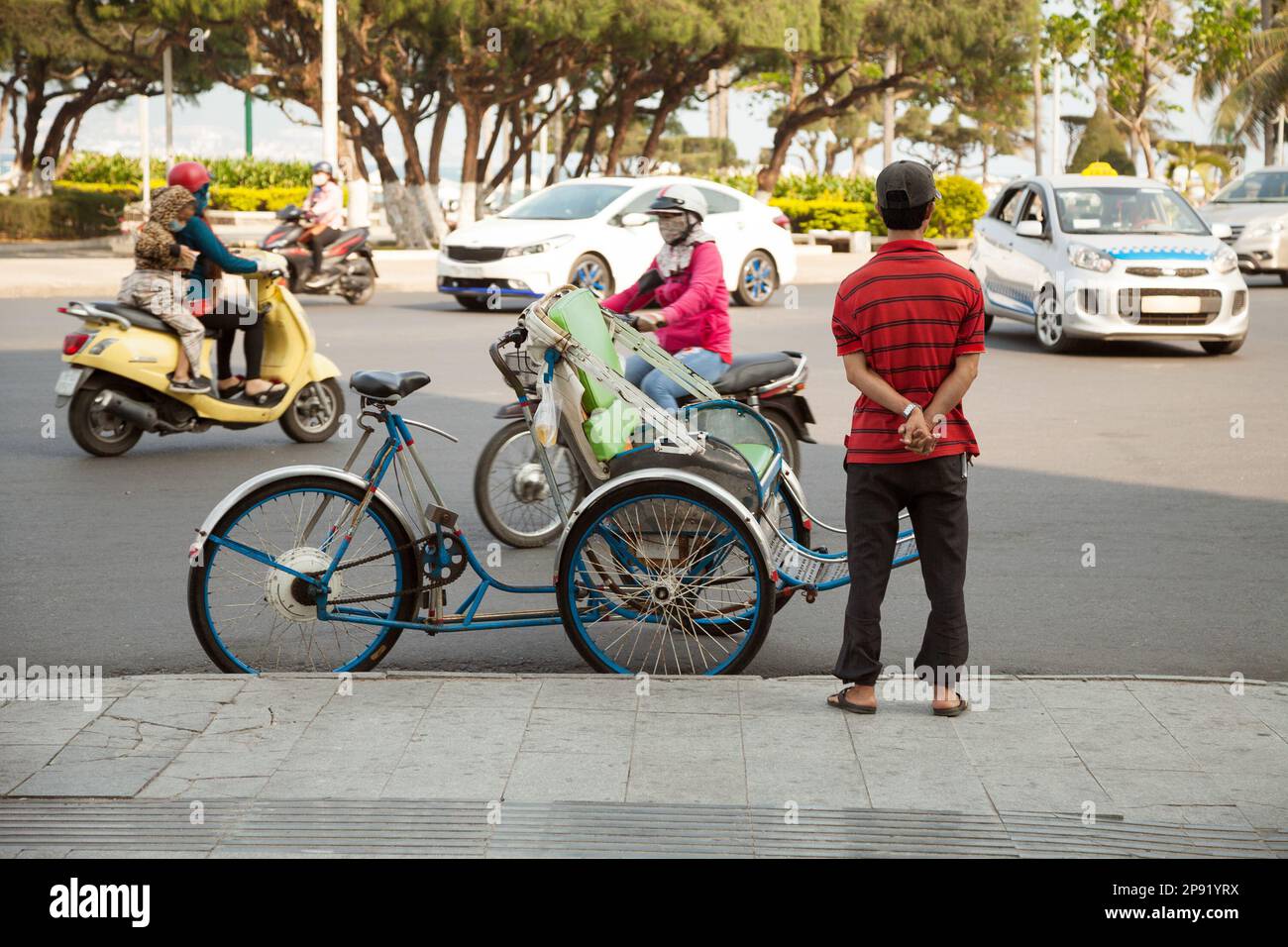 Le Trishaw vacants en attente de clients sur une rue de ville d'Asie. Divertissement touristique type de transport - vélo-taxi. Pilote de transport Tricycle debout Banque D'Images