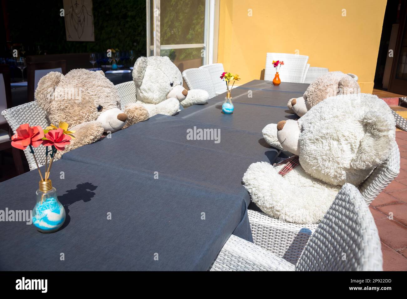 Un groupe d'ours Teddy assis à une table et prêt pour un déjeuner ou une réunion Banque D'Images