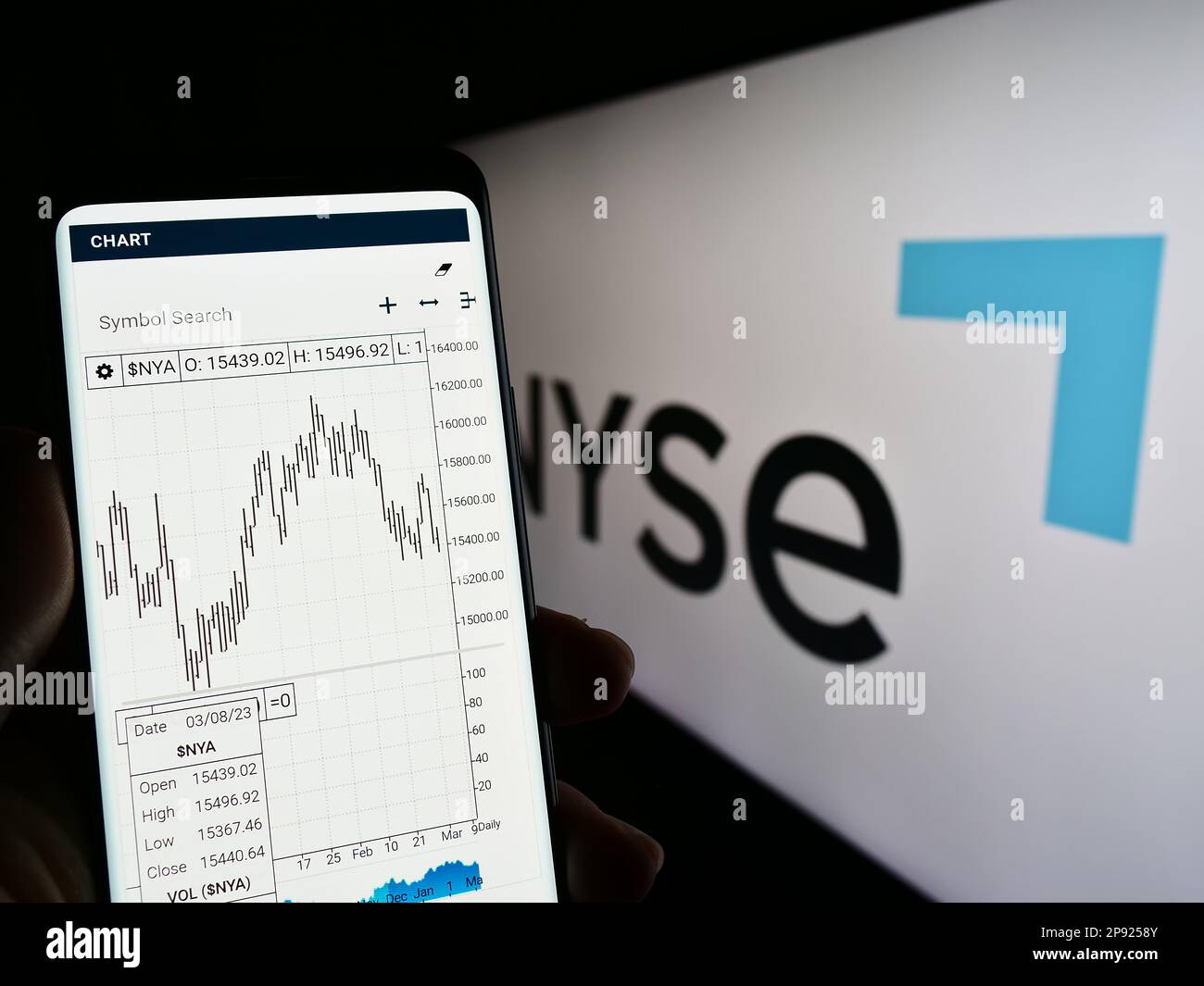 Personne tenant un téléphone portable avec la page web du marché américain de la Bourse de New York (NYSE) à l'écran devant le logo. Concentrez-vous sur le centre de l'écran du téléphone. Banque D'Images