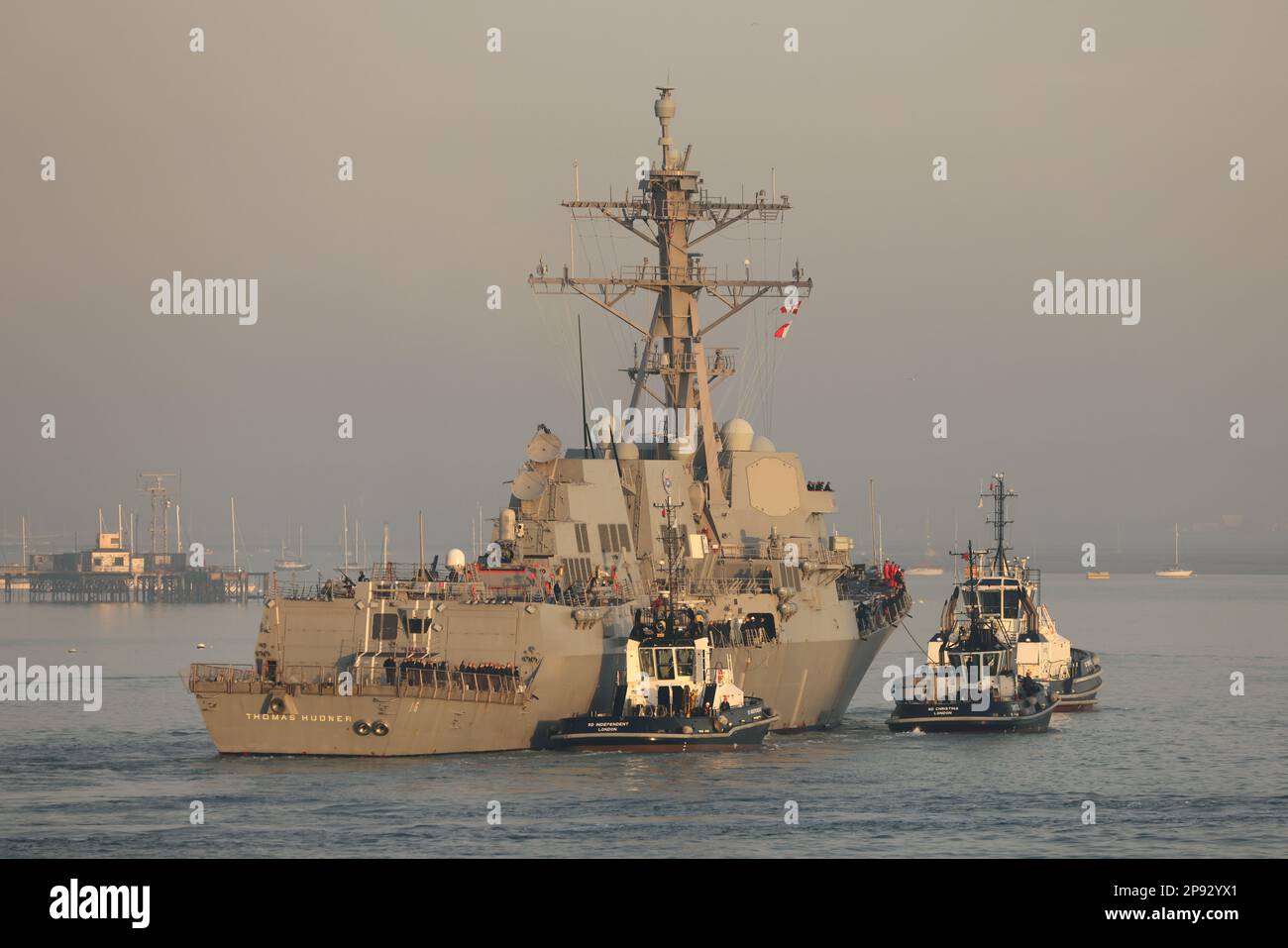 Les remorqueurs de la base navale guident le destroyer USS THOMAS HUDNER de la marine des États-Unis vers un poste d'amarrage dans la base navale Banque D'Images