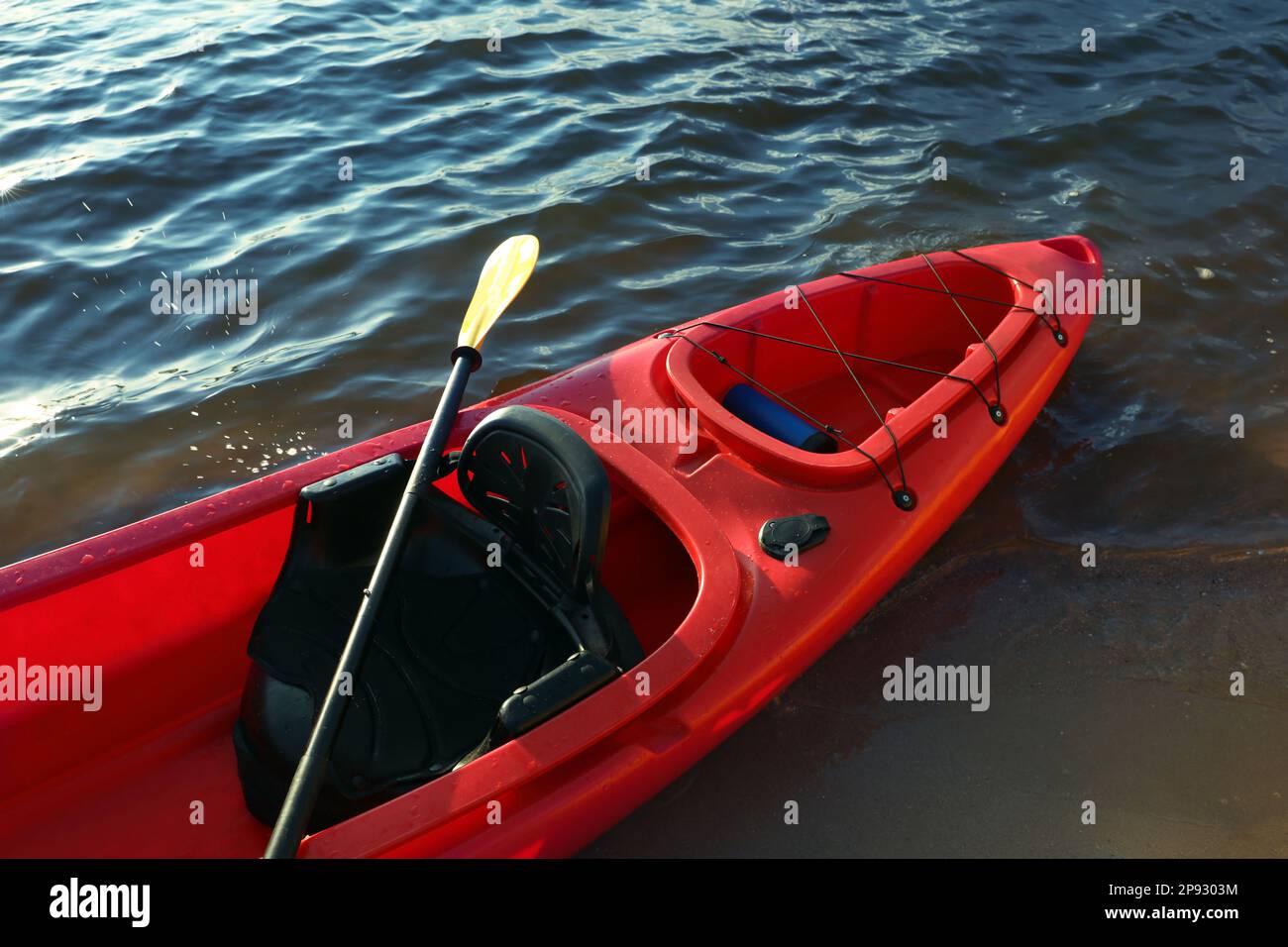 Magnifique kayak rouge moderne avec paddle sur la plage Banque D'Images Magnifique kayak rouge moderne avec paddle sur la plage Banque D'Images