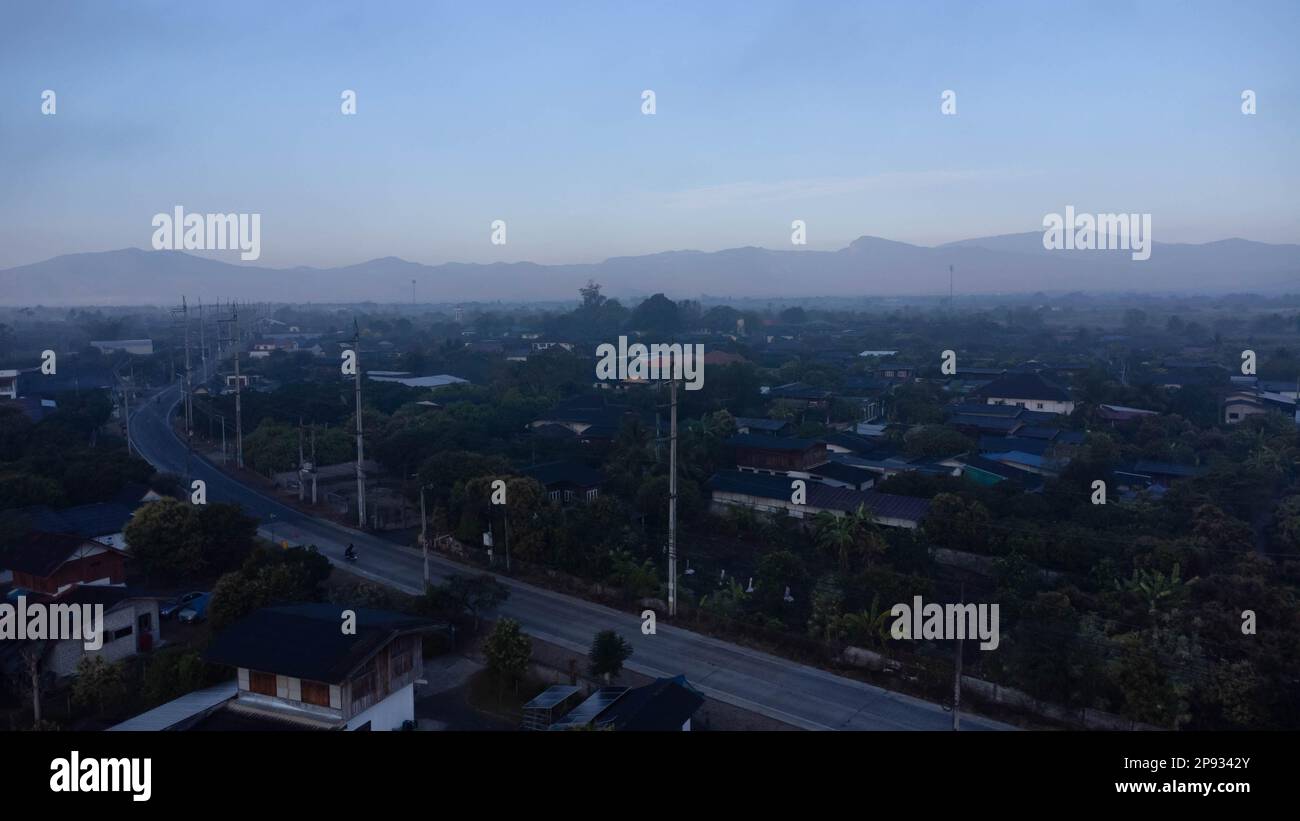 Vue aérienne d'un village rural entouré de smog par les activités de combustion. Zones à smog dense et couvertes de PM2,5. Pollution de l'air et PR écologique Banque D'Images