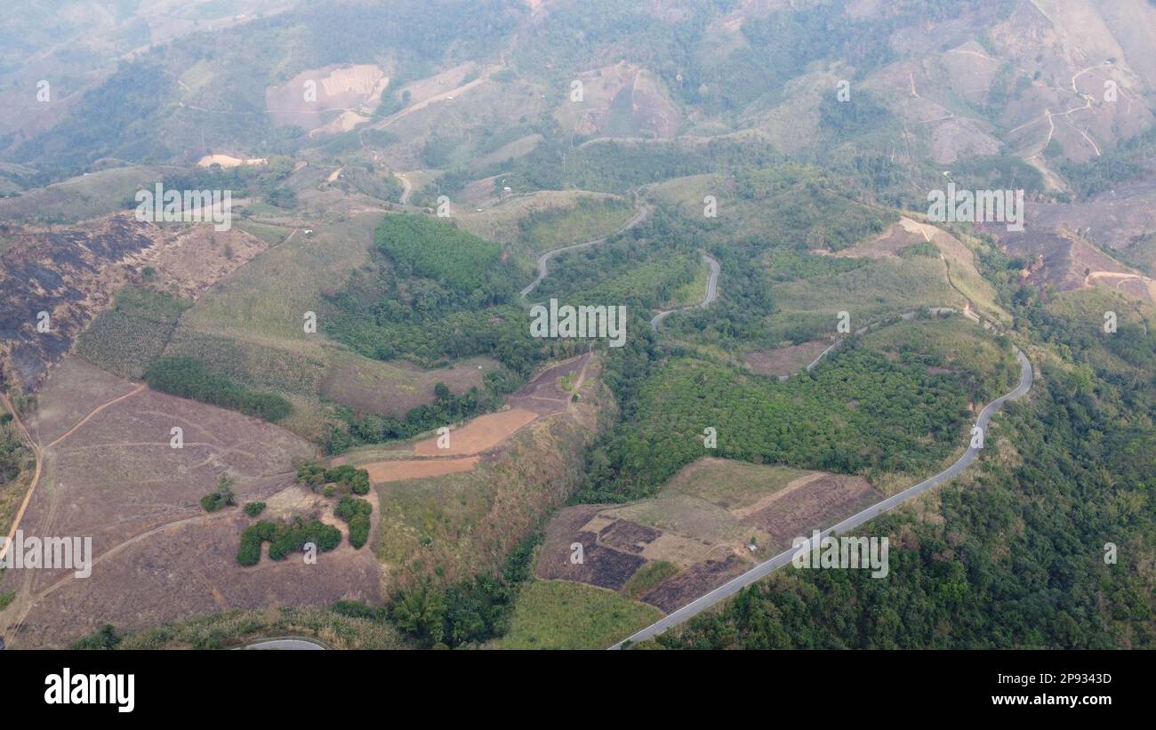 Montagne détruite par l'homme pour cultiver des plantes. Vue aérienne des montagnes couvertes de brume provenant des forêts en feu. Zones à smog dense et couvertes Banque D'Images