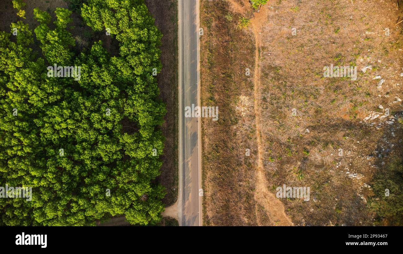Vue aérienne d'une route qui traverse une forêt luxuriante, de l'autre côté est une zone détruite par les humains pour la culture de cultures de montagne. Zones avec Banque D'Images
