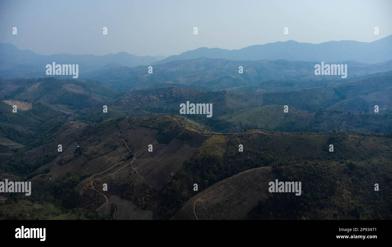 Montagne détruite par l'homme pour cultiver des plantes. Vue aérienne des montagnes couvertes de brume provenant des forêts en feu. Zones à smog dense et couvertes Banque D'Images