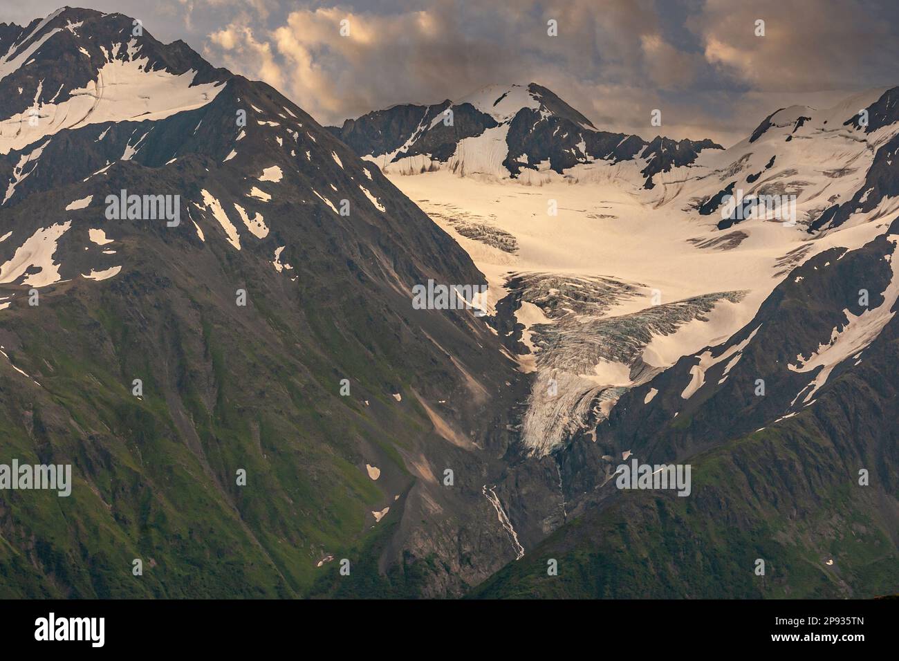 Girdwood Alaska, Etats-Unis - 23 juillet 2011: Glacier blanc au sommet de la chaîne de montagnes de roche noire dans le parc de Chugach au-dessus de la ville. Flancs abrupts légèrement recouverts de Banque D'Images