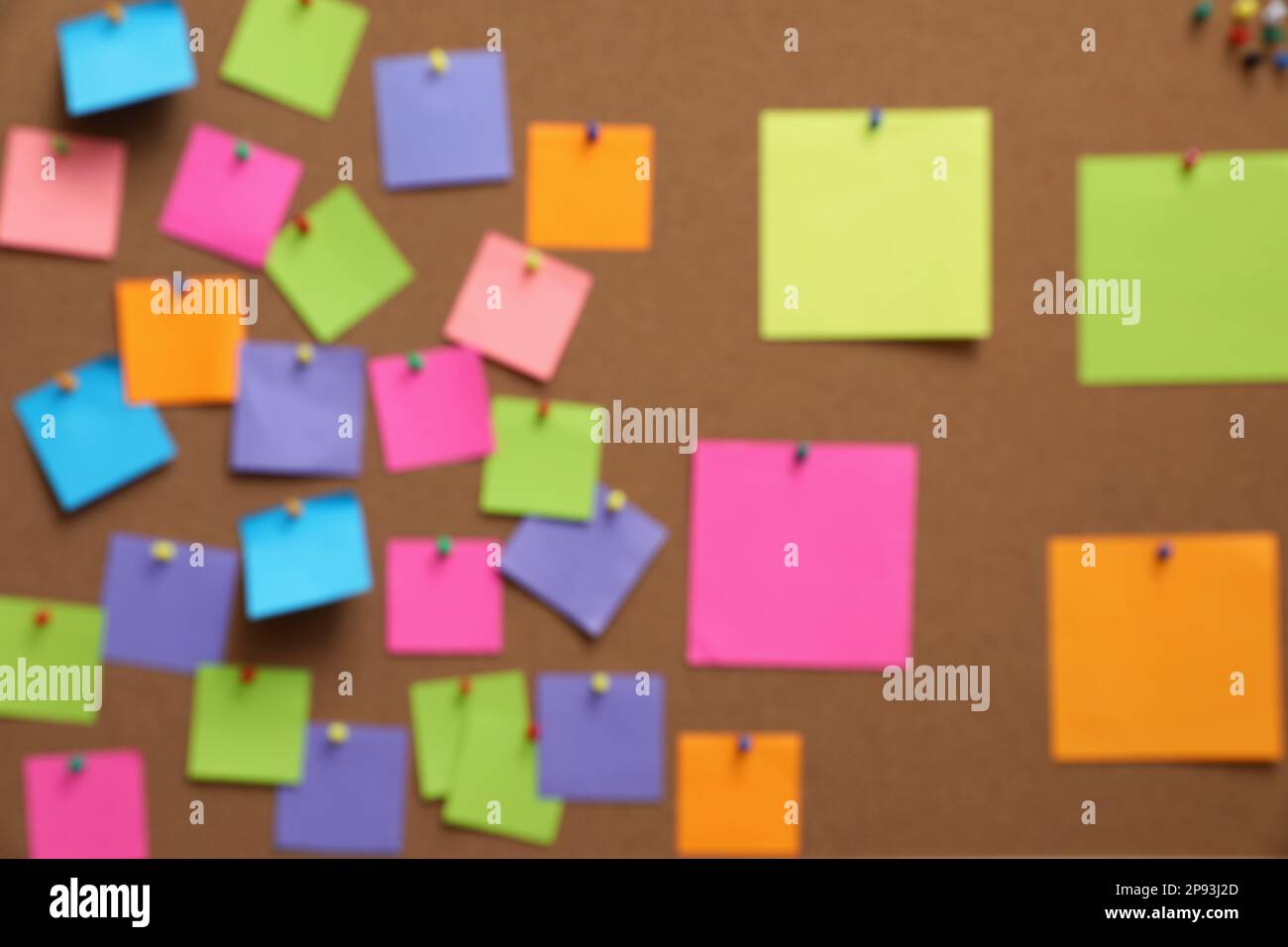Vue floue du tableau rempli de notes et de épingles colorées Banque D'Images