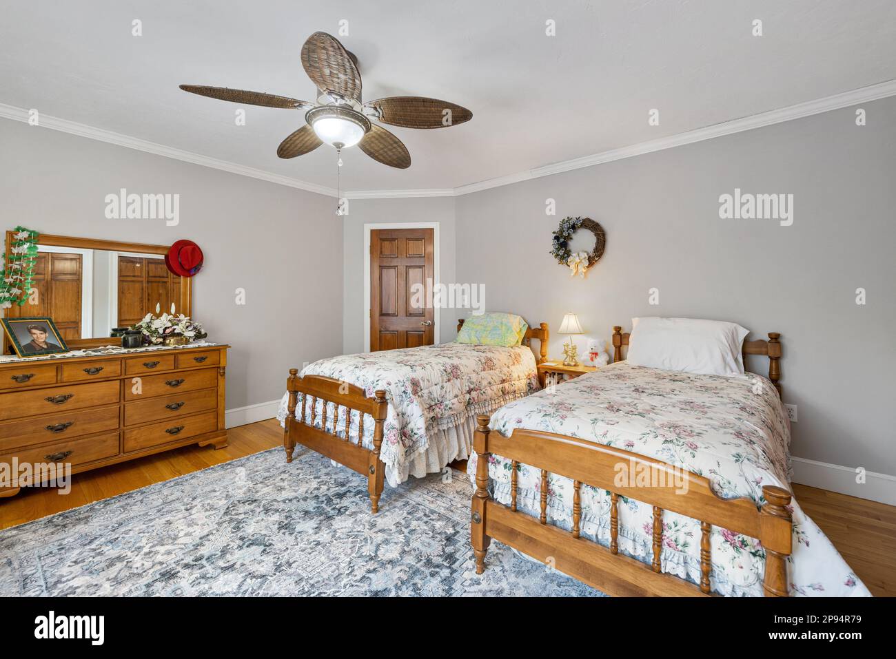 Une chambre confortable avec deux lits simples, une porte et un ventilateur de plafond en Nouvelle-Angleterre Banque D'Images