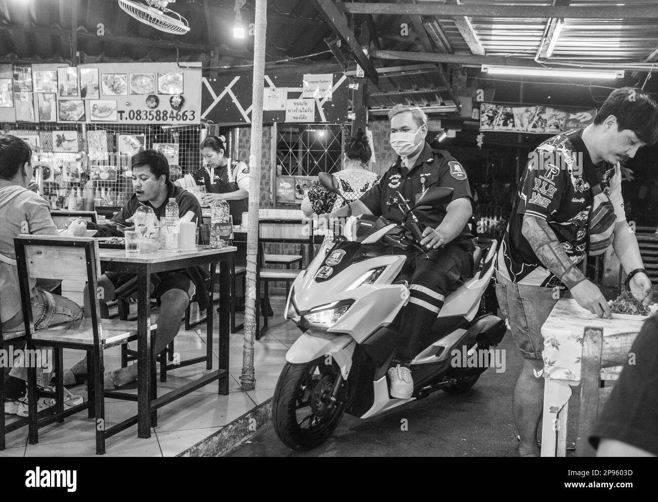 Un restaurant de rue traditionnel avec un passage étroit pour les scooters en Thaïlande Asie Banque D'Images