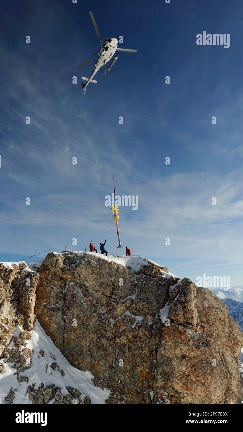 A helicopter airlifts the summit cross from the top of Germany's highest mountain, the 2,962 meters Zugspitze, near Garmisch-Partenkirchen, southern Germany, Monday, Jan. 26, 2009. The 16-year-old cross was taken to the mountain's base, from where it will be transported for a restoration that is expected to last until Easter. (AP Photo/Christof Stache) Banque D'Images