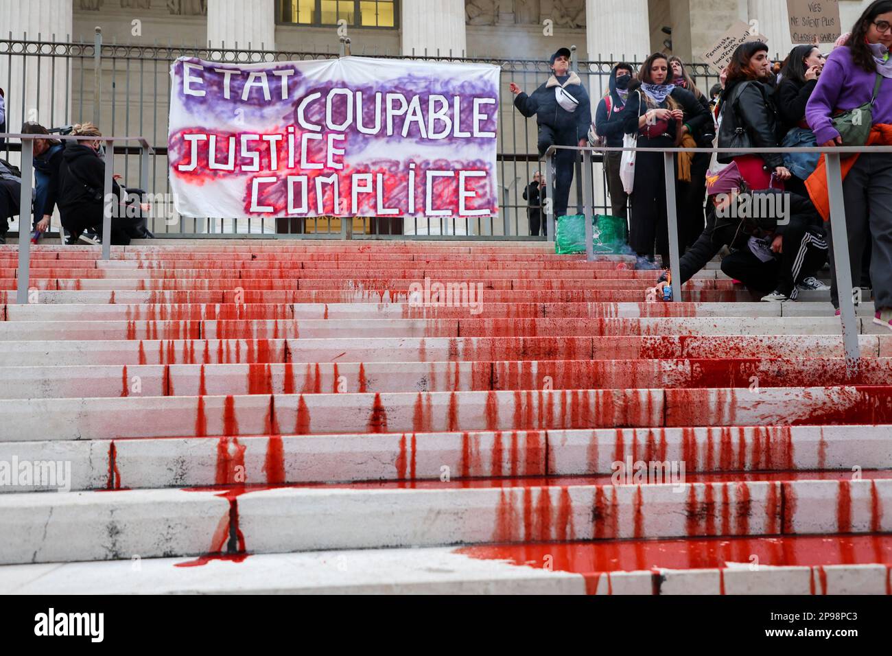Les manifestants accrochent une bannière à la porte du palais de justice de Marseille et versent de la teinture rouge sur les marches représentant le sang des victimes du féminisme. À l'occasion de la Journée internationale des droits de la femme, plusieurs personnes ont manifesté dans les rues de Marseille. Banque D'Images