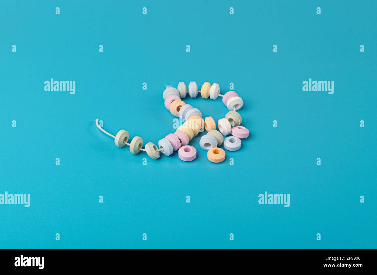 Bracelet de bonbons, confiserie en poudre de sucre comprimé, pièces de collier de bonbons Dextrose, pastilles sur fond bleu Banque D'Images