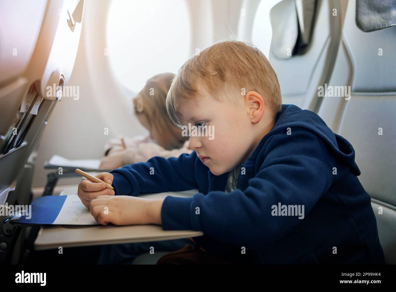 les enfants volent en avion et dessine avec un crayon dans un livre de