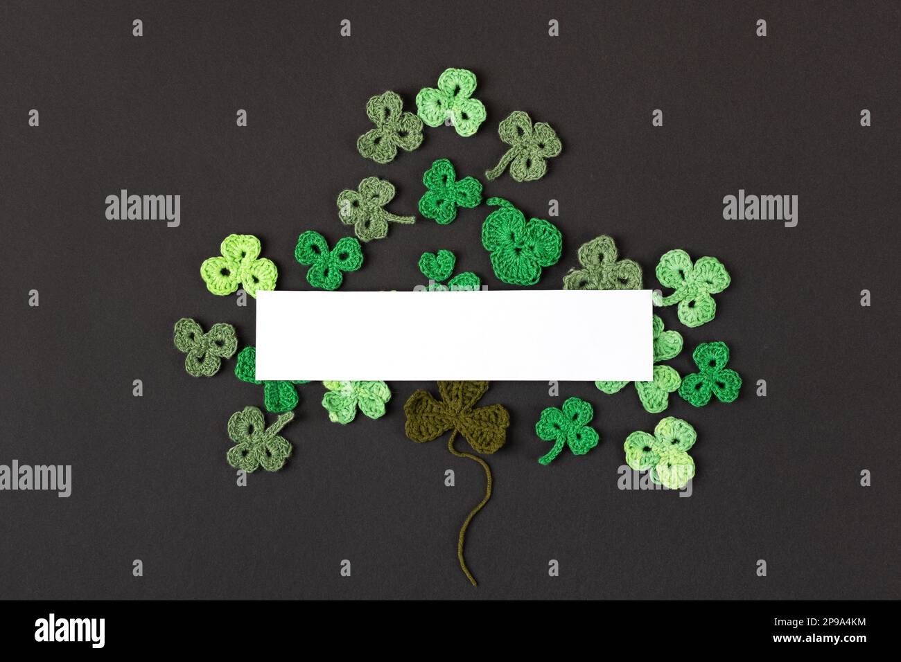 Concept de la St Patrick. Composition en shampoings verts tricotés sous forme de trèfle à trois feuilles sur fond noir. Affiche des fêtes et tricoté Banque D'Images