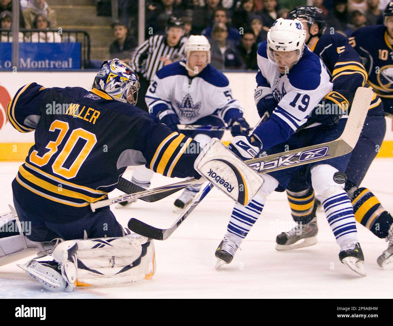 Buffalo Sabres goaltender Ryan Miller (30) makes a save as defenseman Jaroslav Spacek, right, picks up a holding penalty while trying to defend Toronto Maple Leafs center Dominic Moore (19) during the second period of an NHL hockey game in Toronto on Thursday, Jan. 1, 2009. (AP Photo/The Canadian Press, Frank Gunn) Banque D'Images