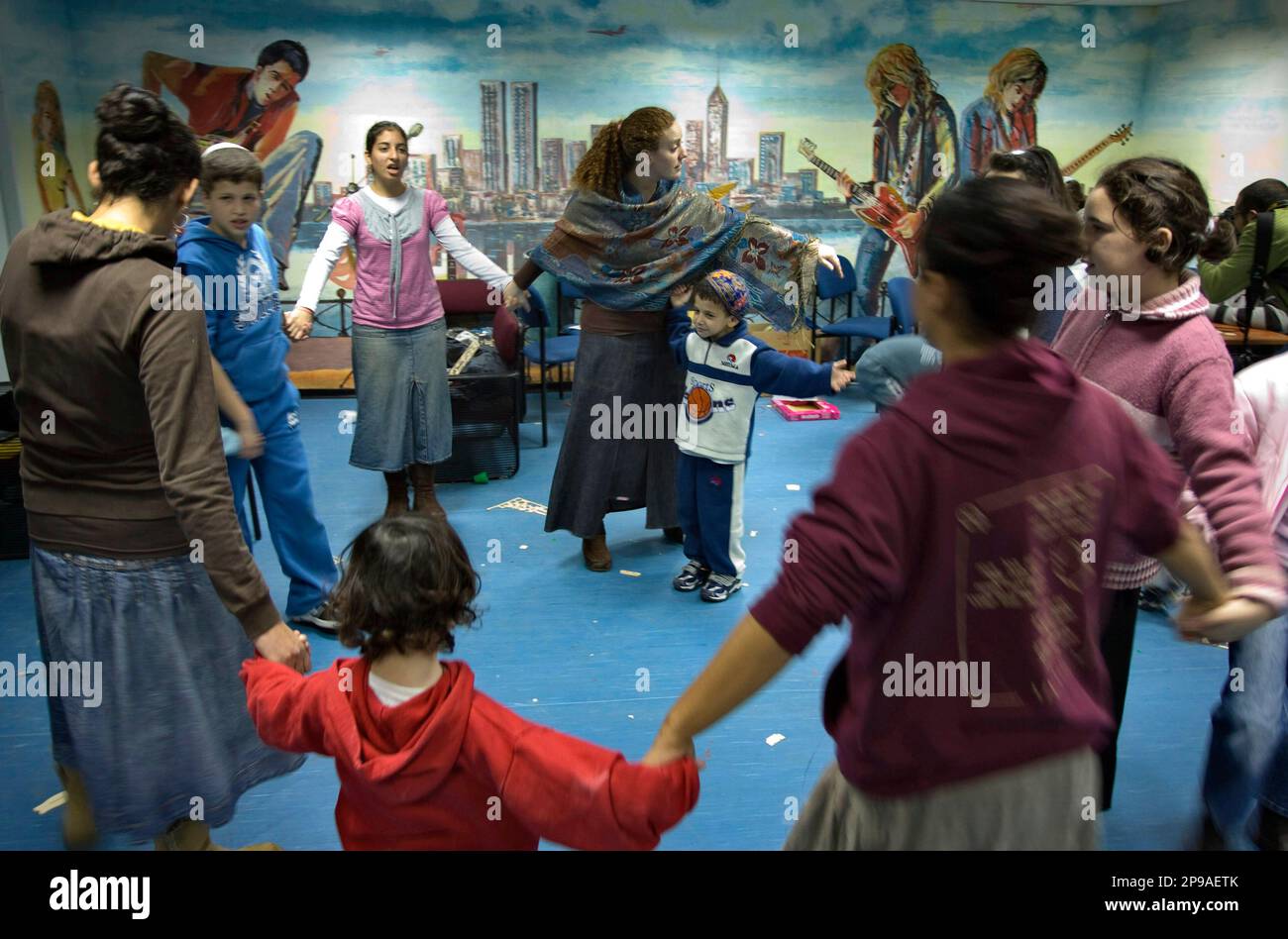 Volunteers dance with Israeli children and youths who are out of school and were called to stay inside a shelter in the southern Israel city of Ashkelon, Wednesday, Dec. 31, 2008. Israel has rejected mounting international pressure to suspend its devastating air offensive against Palestinian militants in the Gaza Strip. (AP Photo/Sebastian Scheiner) Banque D'Images