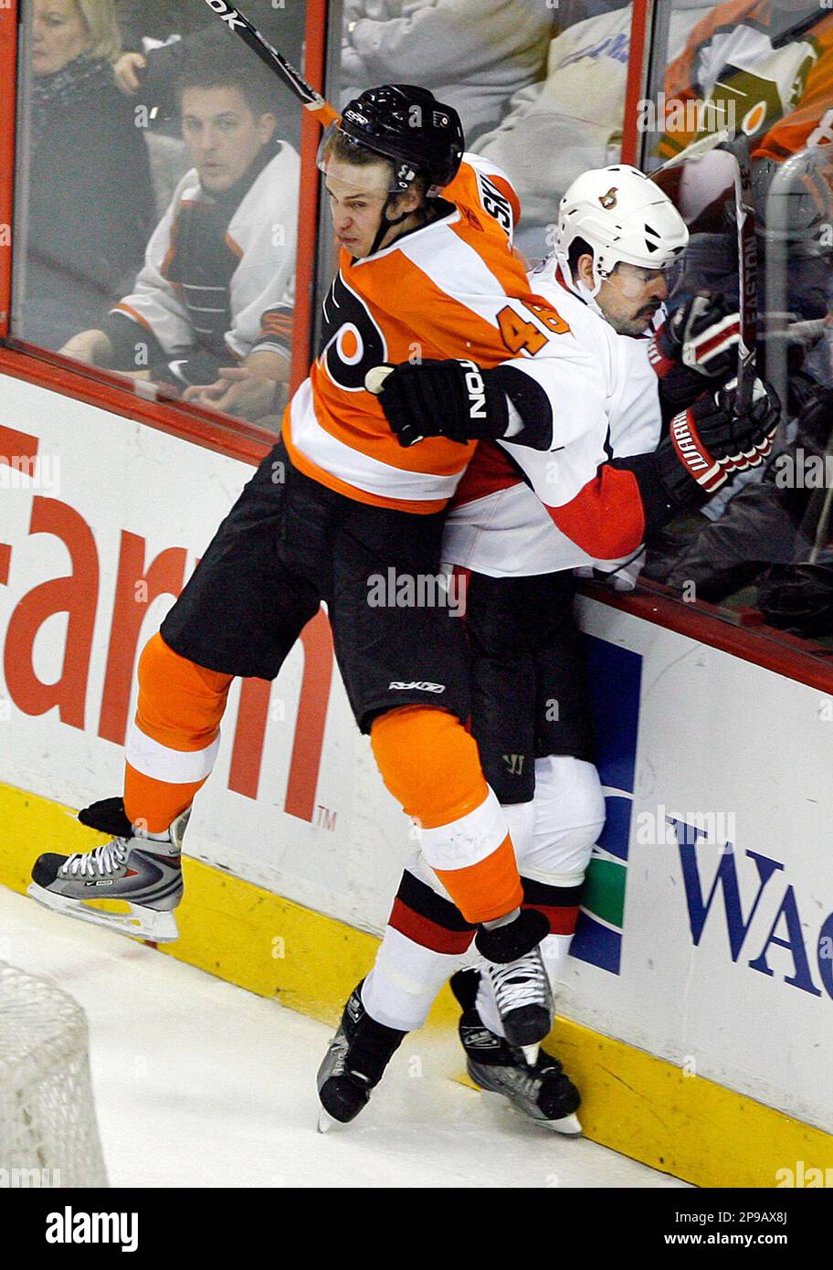 Philadelphia Flyers left wing Jonathon Kalinski slams Ottawa Senators defenseman Chris Phillips into the boards in the third period of an NHL hockey game Tuesday, Dec. 23, 2008, in Philadelphia. The Flyers won 6-4. (AP Photo/Tom Mihalek) Banque D'Images