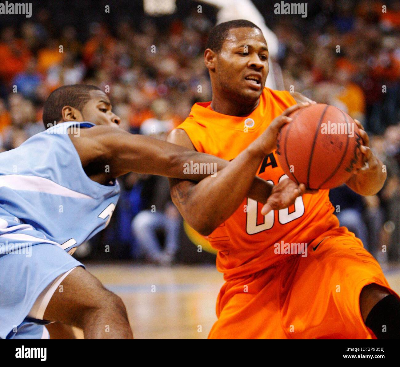 Rhode Island guard Stevie Mejia, left, reaches in to try and take the ball away from Oklahoma State guard Byron Eaton, right, in the first half of an NCAA college basketball game in Oklahoma City, Saturday, Dec. 20, 2008. (AP Photo/Sue Ogrocki) Banque D'Images