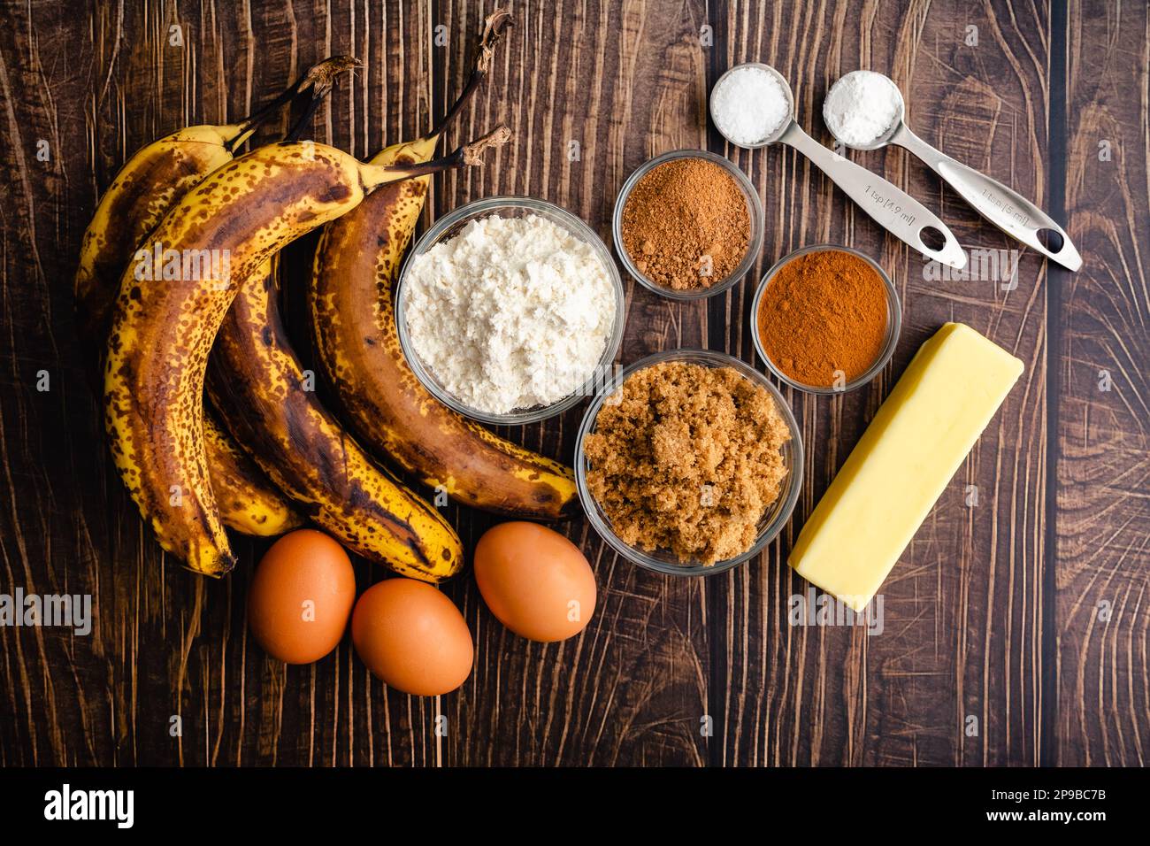 Pain banana au beurre brun Ingrédients sur une table rustique en bois : bananes mûres, farine, sucre brun et autres ingrédients crus Banque D'Images