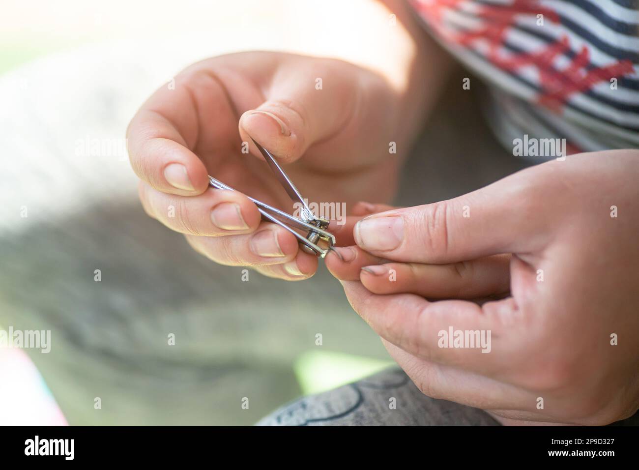 Les mains de maman coupent les ongles sales de l