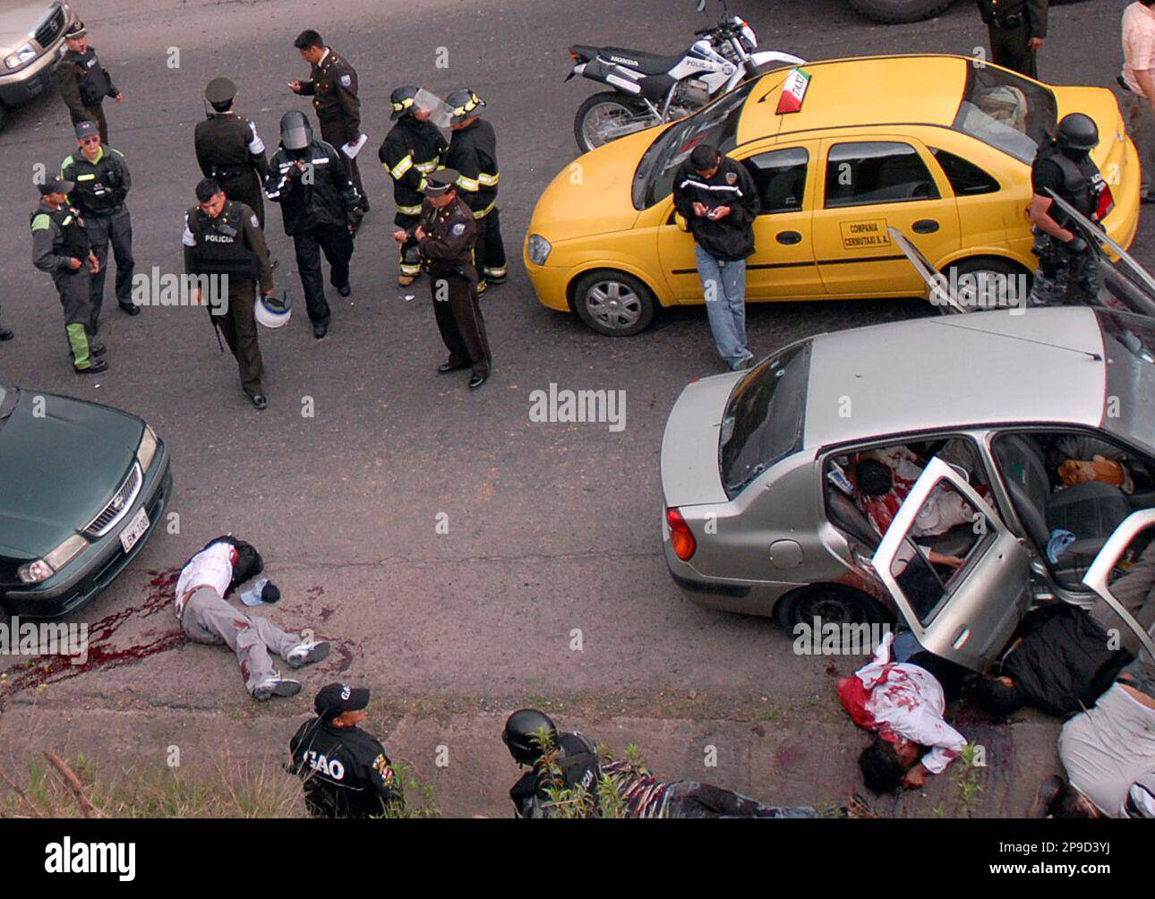 ** EDS NOTE GRAPHIC CONTENT ** Police officers stand next to the bodies of nine alleged criminals after they were gunned down by the police in Pintag, Ecuador, Friday, Nov. 28, 2008. The alleged thieves were chased and killed after they robbed a gas station and a dairy products company. (AP Photo) Banque D'Images