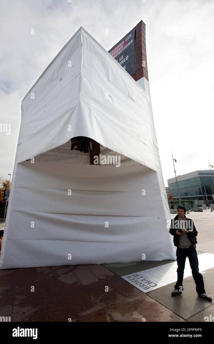 The "Broken Chair" sculpture has been shrouded in a white sheet by Handicap International to encourage states to ban cluster bombs and sign the Oslo convention, in front of the European headquarters of the United Nations in Geneva, Switzerland, Monday, Nov. 3, 2008. The Broken Chair stands at the Place des Nations to symbolize victims of the anti-person mines. (AP Photo/Keystone, Laurent Gillieron) Banque D'Images