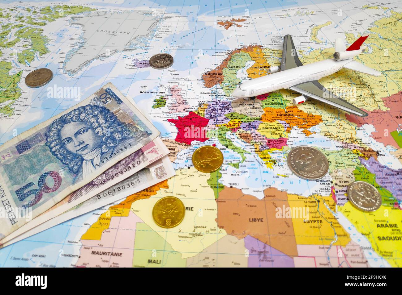 Zagreb, Croatie - 09 juillet 2019: Composition d'une carte du monde centrée sur la Croatie avec sur elle, quelques billets et pièces Kuna ainsi qu'un avion de jouet. Banque D'Images