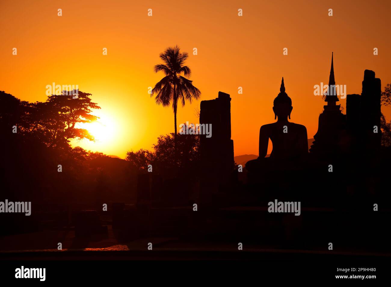 Silhouette des ruines de l'ancien temple bouddhiste Wat Chana Songkhram sur fond de coucher de soleil orange. Parc historique de Sukhotai. Thaïlande Banque D'Images