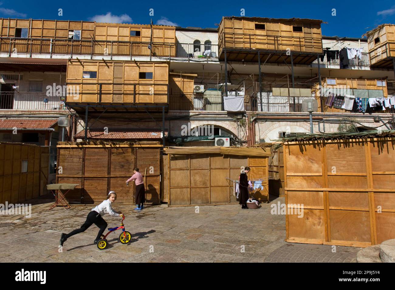 An Israeli ultra-orthodox Jewish boy rides a tricycle past Sukkah's in the neighborhood of Mea Shearim, in Jerusalem, Friday, Oct. 10, 2008. The Sukkah is built and lived in during the week-long Jewish holiday of Sukkot, also known as the Feast of Tabernacles, named for the shelters the Israelites lived in as they wandered the desert for 40 years. (AP Photo/Bernat Armangue) Banque D'Images