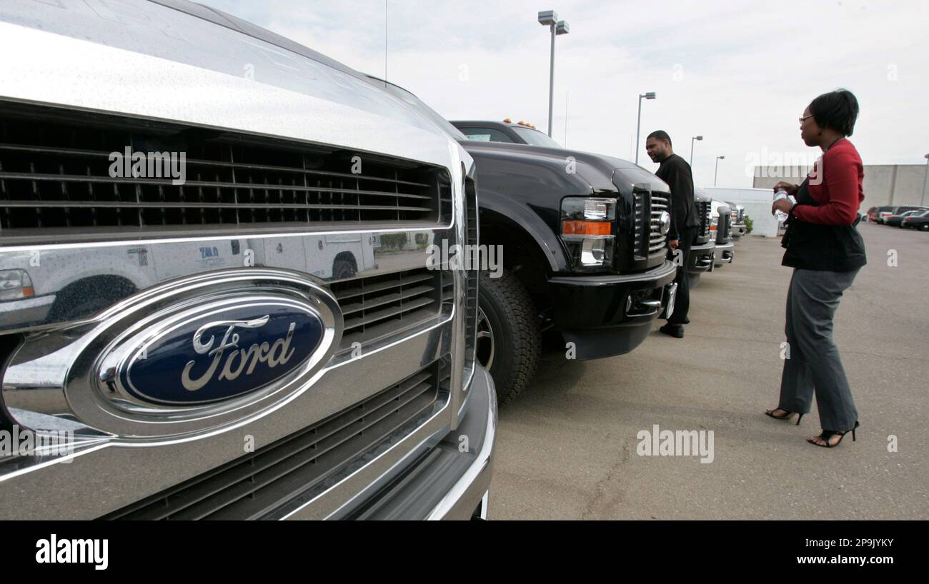 Ford customers Kim Cloud, left, and his sister, Kendra Roberts, right, looks at trucks at a Ford dealership in San Leandro, Calif., Wednesday, Oct. 1, 2008. Tight credit, economic worries and high gasoline prices combined to crush the sales of U.S. and foreign automakers alike last month, with Ford Motor Co., Toyota Motor Corp. and Chrysler LLC all posting drops of more than 30 percent. (AP Photo/Paul Sakuma) Banque D'Images