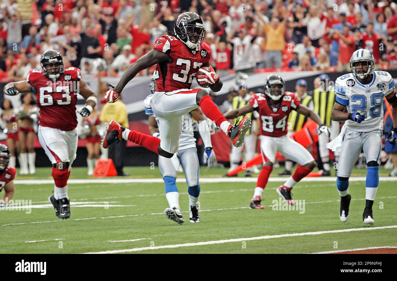 Atlanta Falcons running back Jerious Norwood (32) leaps into the air during a second-half touchdown run during an NFL football game against the Detroit Lions at the Georgia Dome in Atlanta, Sunday, Sept. 7, 2008. The Lions' Leigh Bodden (28) defends as the Falcons' Justin Blalock (63) and Roddy White (84) watch on. (AP Photo/Dave Martin) Banque D'Images