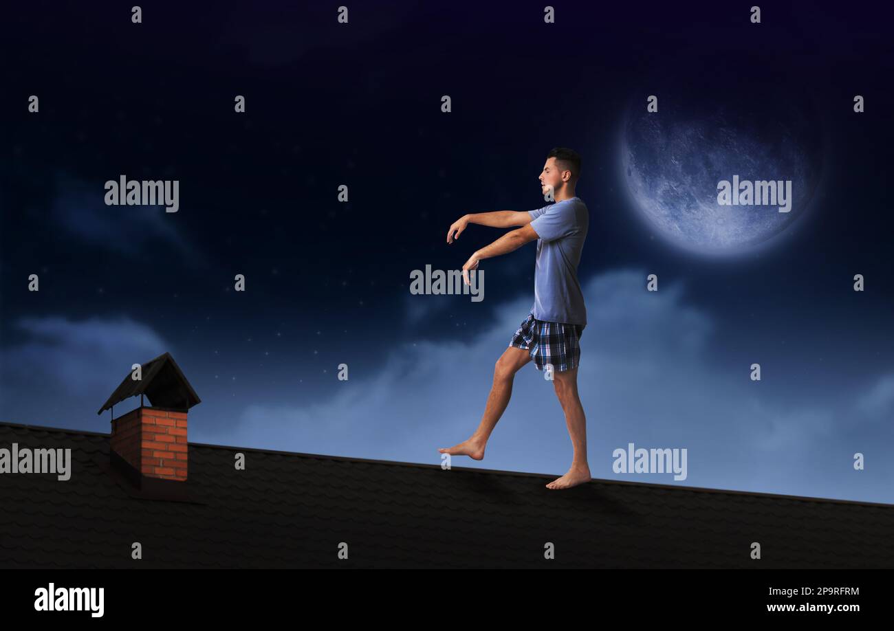 Sleepwalker portant un pyjama sur le toit la nuit Banque D'Images