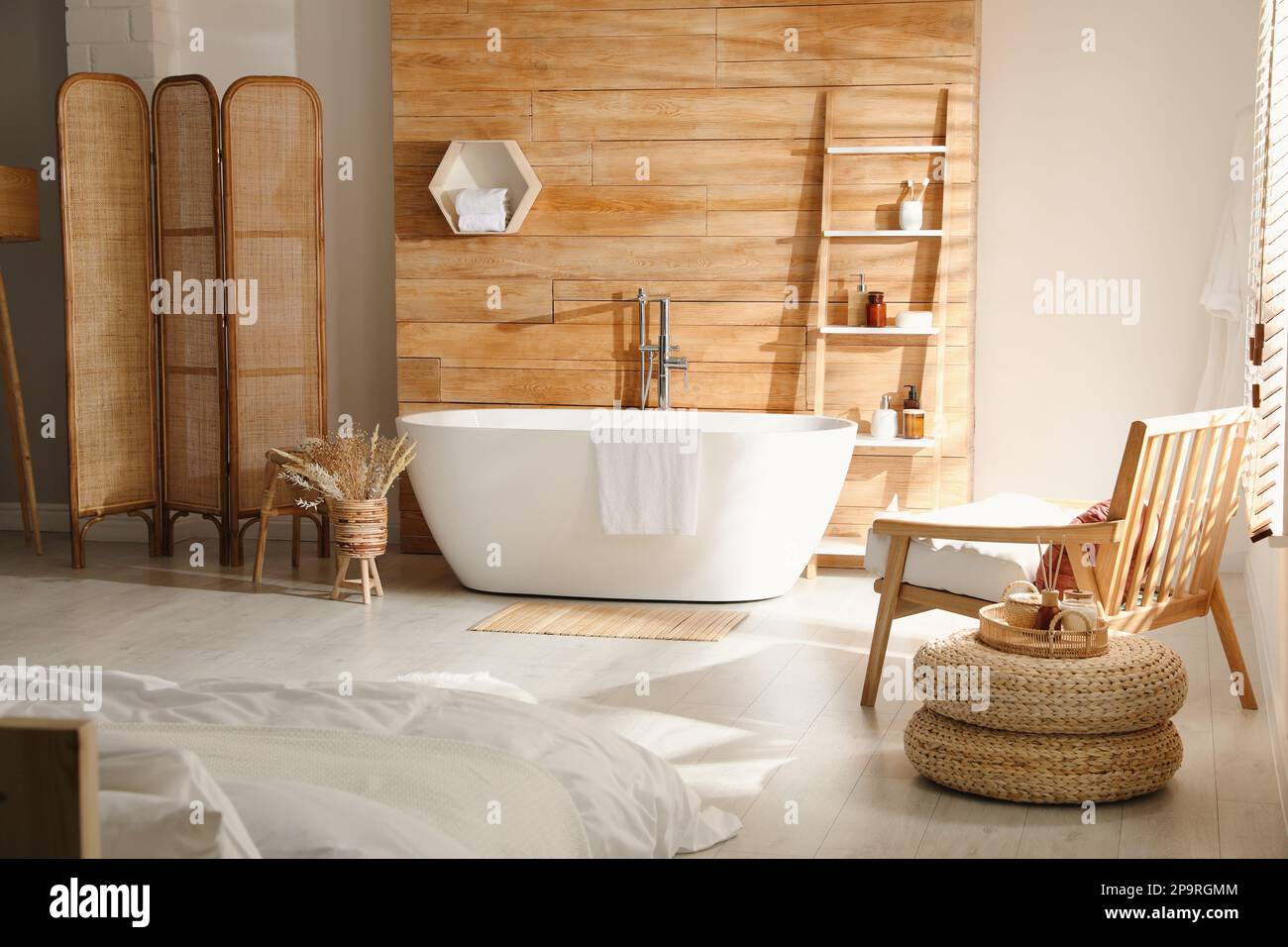 Intérieur élégant de l'appartement avec baignoire et lit blancs Banque D'Images