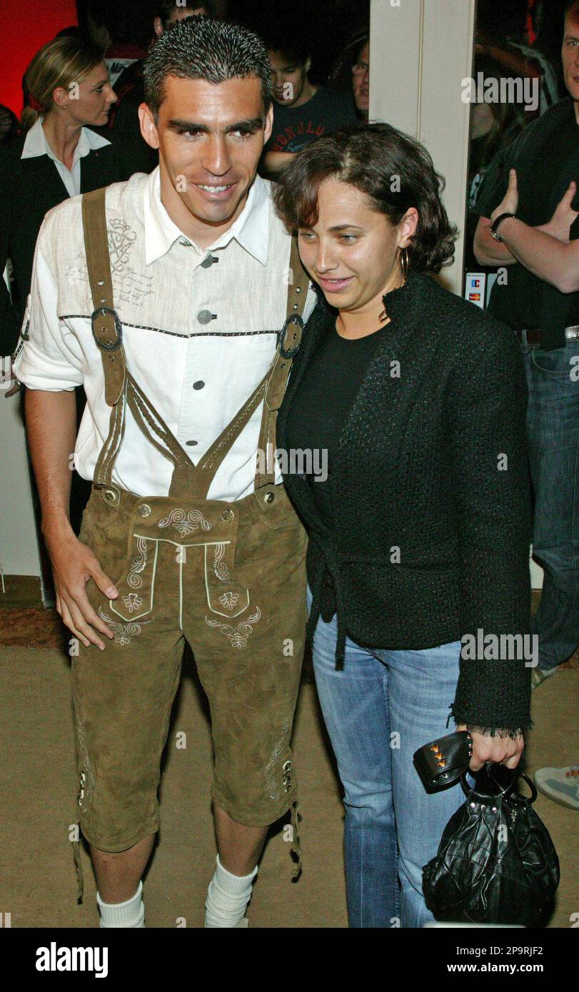 ** FILE ** In this April 30, 2005 file photo, Lucimar da Silva Ferreira, called "Lucio", Brazilian defender of Munich soccer club FC Bayern Munich wears traditional Bavarian leather trousers as he arrives with his wife Dione to celebrate the club's win of the 19th German soccer championship in a restaurant in Munich, southern Germany. Bayern Munich is already offering yoga and language classes to its players. Now, cooking courses will be available to their wives. "I have absolutely nothing against the beans soup of Mrs. Lucio, but the diet should be balanced," general manager Uli Hoeness said Banque D'Images