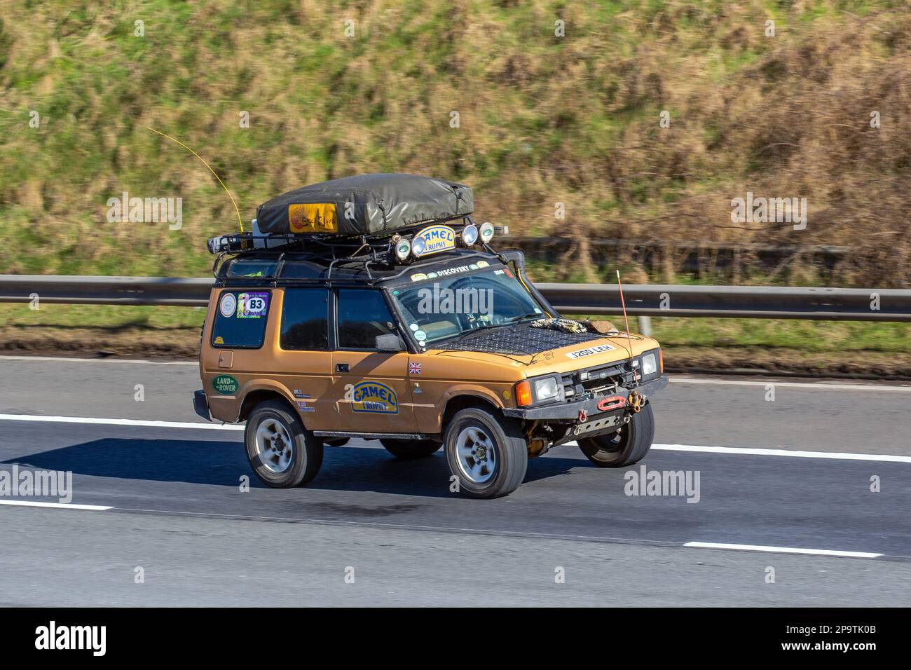 Années 1992 90 Orange Camel Trophy Land Rover Defender. Loisir d'expédition vintage, 4x4 tout-terrain britannique, véhicule d'aventure tout-terrain tout-terrain robuste, LandRover Discovery Turbo Diesel UK ; voyage sur l'autoroute M61, Royaume-Uni Banque D'Images