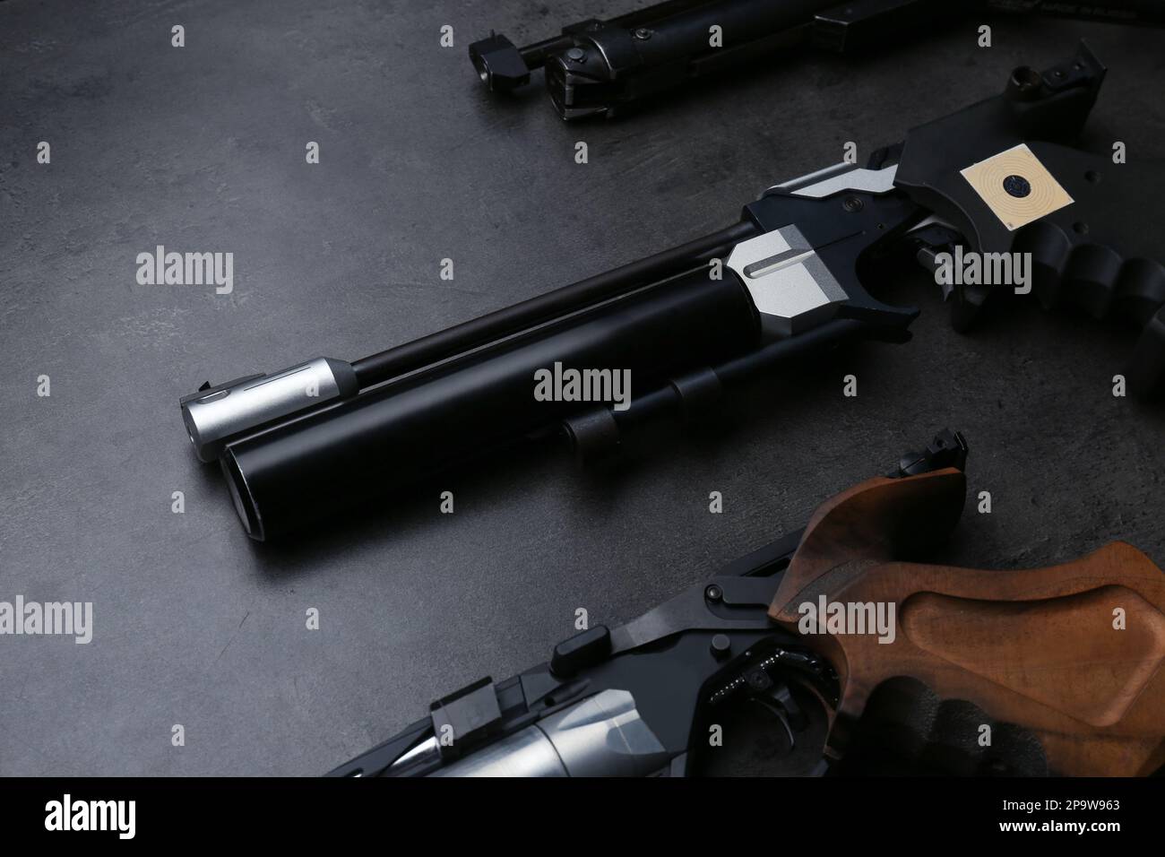 Différents pistolets de sport sur table noire. Pistolets professionnels Banque D'Images