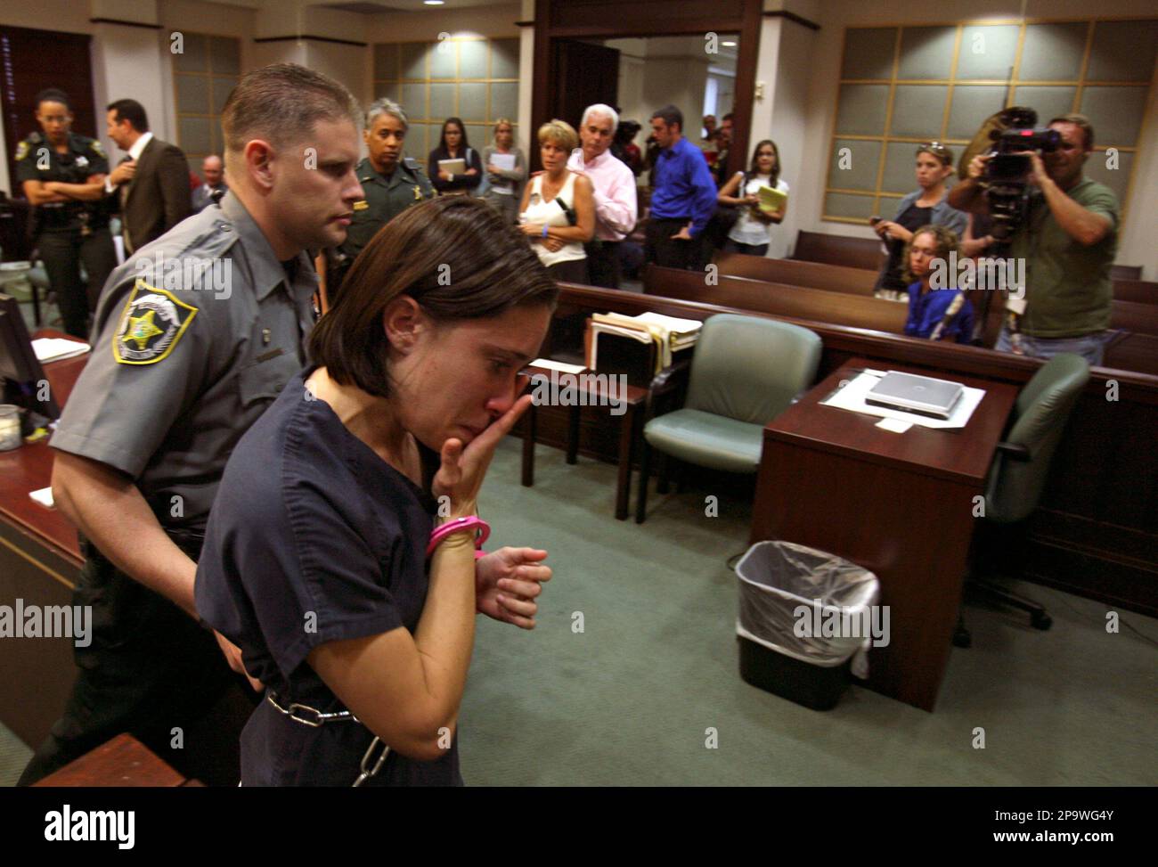 Casey Anthony, foreground, is escorted out of the courtroom, as her