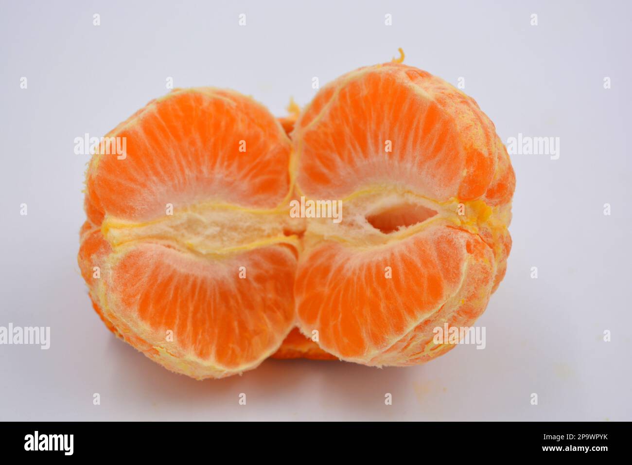 Fruits frais mûrs et délicieux, mandarine d'orange pelée sans peau située sur fond blanc. Banque D'Images