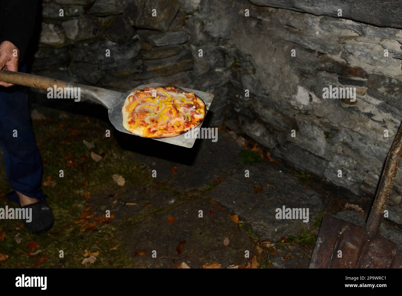 Staycation pizza traditionnelle au feu de bois cuisson dans un four en pierre Banque D'Images
